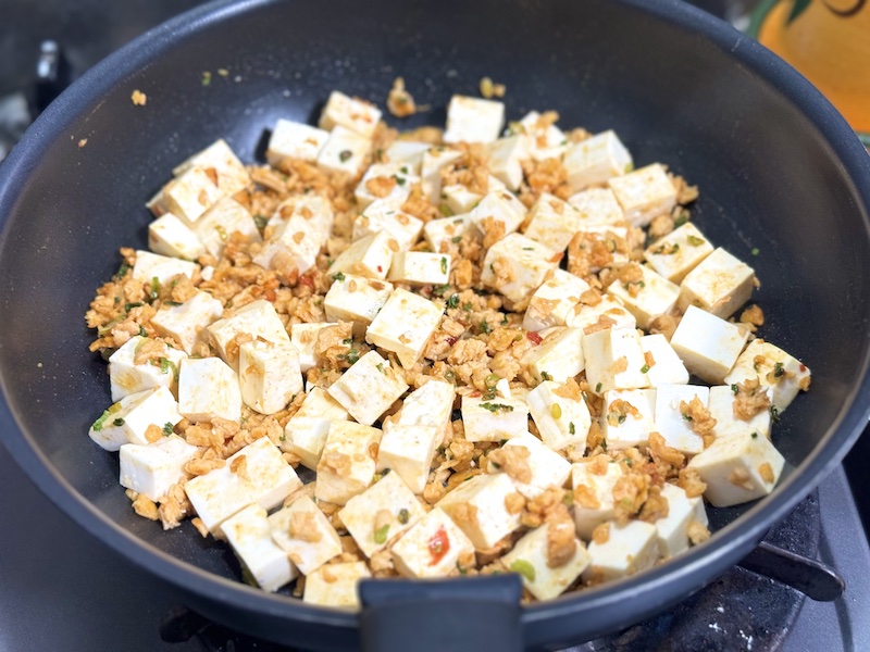 豆腐を入れ、水気を飛ばすように軽く炒める
